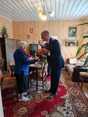 Wójt Gminy Garwolin Marcin Kołodziejczyk wręcza kwiaty jednej z odznaczonych.