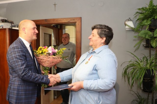 Wójt Gminy Garwolin Marcin Kołodziejczyk wręcza bukiet kwiatów, gratulując Pani Henryce Lasockiej