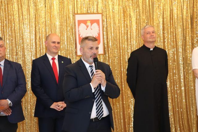 Przemawia Starosta Powiatu Garwolińskiego, w tle stoją: Bernard Makulec, Marcin Kołodziejczyk, ks. Leszek Dąbrowski 